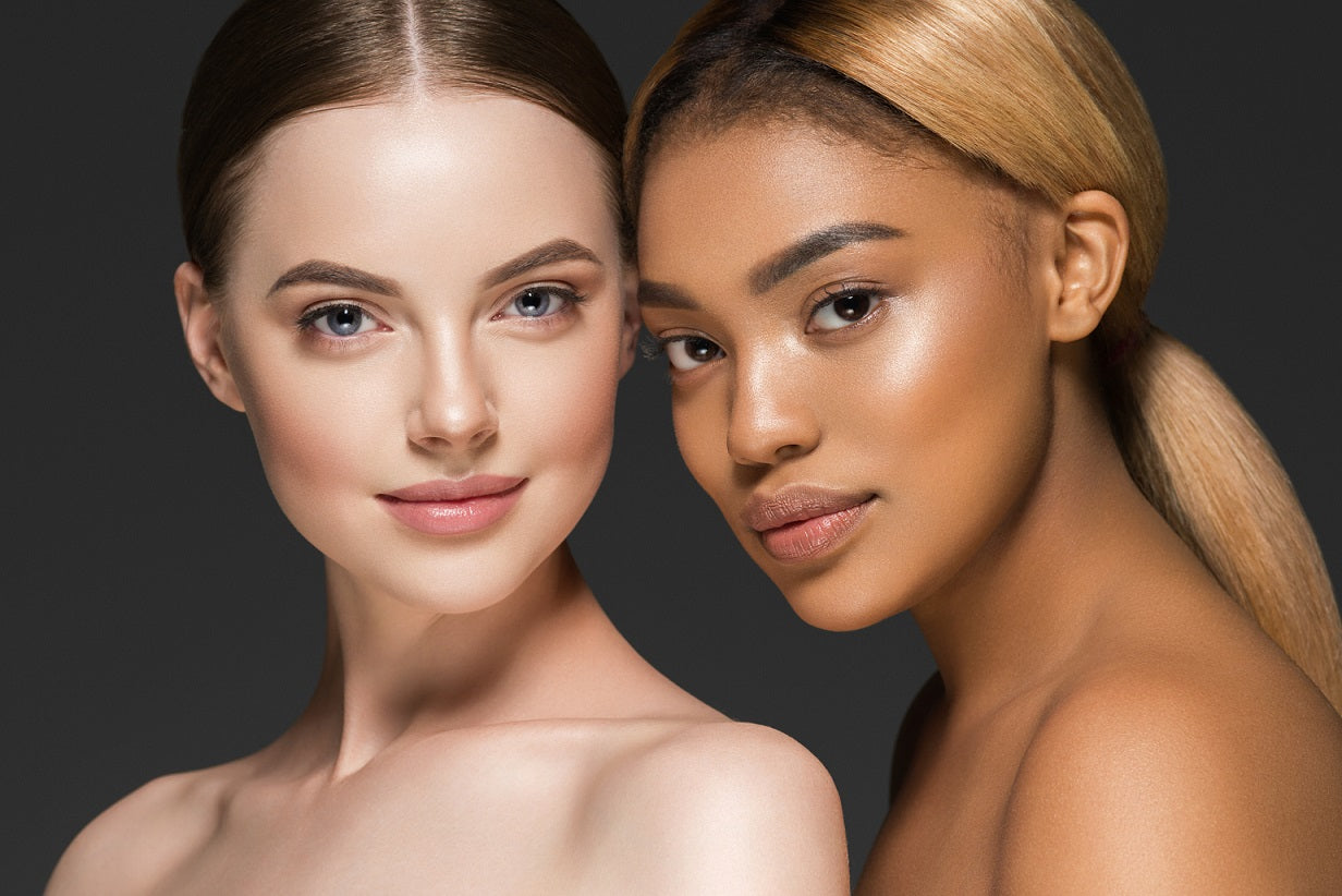 Two women of different races, one with fair skin and the other with darker skin, standing together.