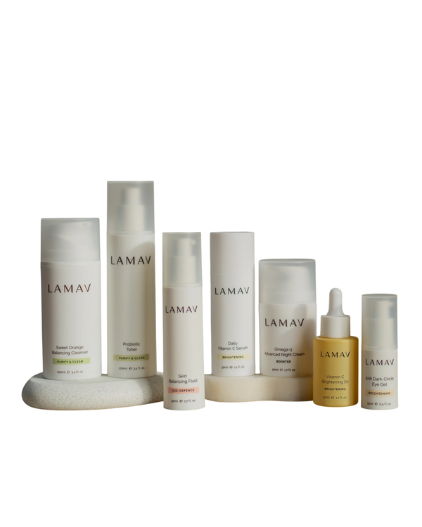 Age-Defence Collection by LAMAV — 7 products lined up on a smooth rounded stone | Control shine and smooth fine lines