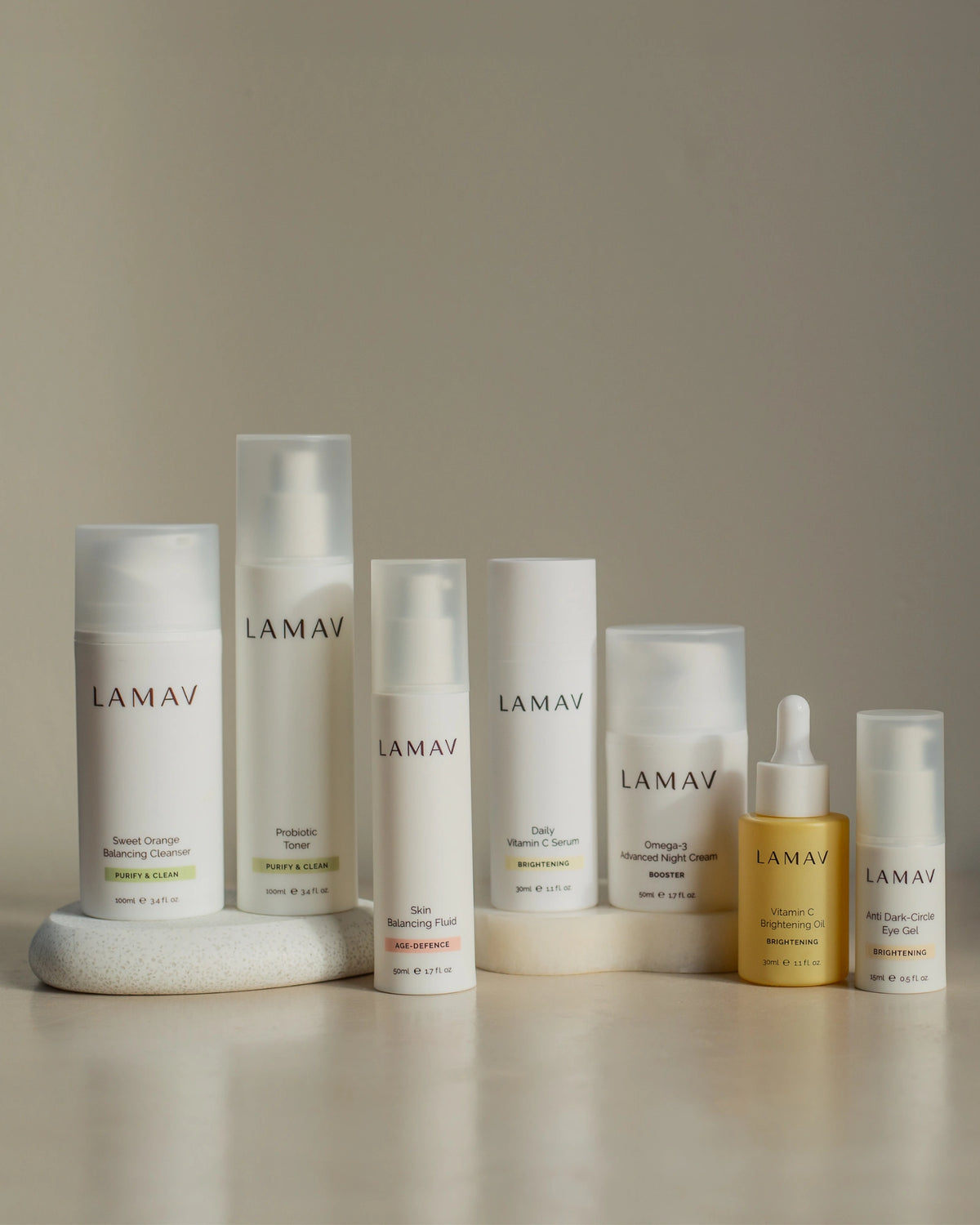 Age-Defence Collection by LAMAV — 7 products lined up on a smooth rounded stone | Control shine and smooth fine lines