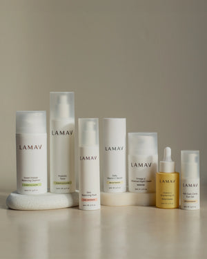 Age-Defence Collection by LAMAV — 7 products lined up on a smooth rounded stone | Control shine and smooth fine lines