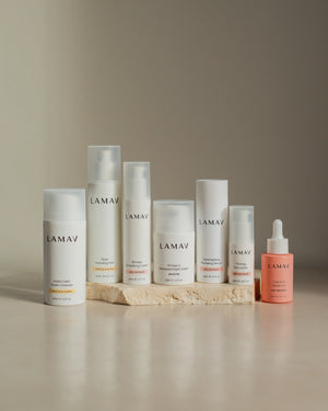 Age-Defence Complete Collection by LAMAV — 7 skincare bottles on a textured stone slab | Complete routine for sensitive skin