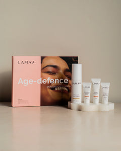 Age-Defence Pack by LAMAV — 4 skincare tubes on a wavy coaster next to pink box | Discover smoother, younger-looking skin