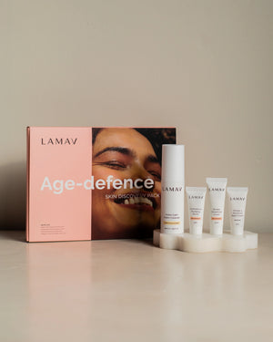 Age-Defence Pack by LAMAV — 4 skincare tubes on a wavy coaster next to pink box | Discover smoother, younger-looking skin