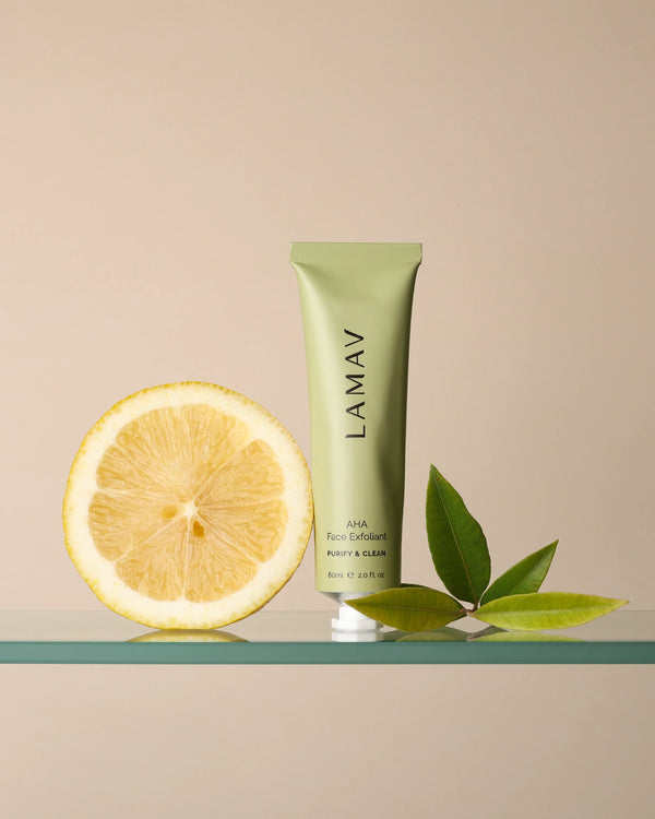 AHA Face Exfoliant by LAMAV — standing tube next to a cut lemon and green leaves | Natural fruit acids for radiant skin