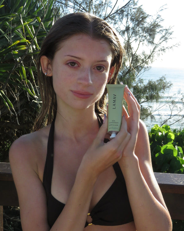 AHA Face Exfoliant by LAMAV — woman holding tube outdoors near the ocean | Achieve a smooth, clear summer glow