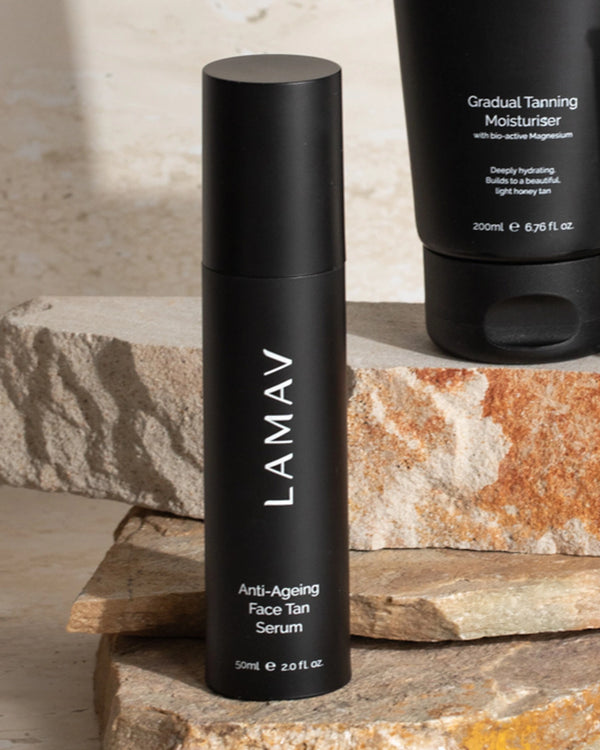 Anti-Ageing Face Tan Serum by LAMAV — bottle on stacked stones next to moisturiser | hydrate and tan