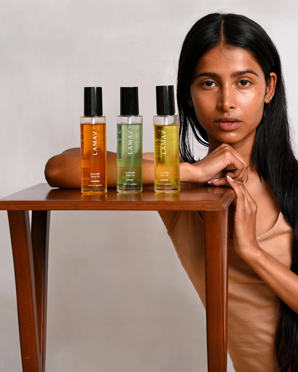 Ayurvedic Body Oil Nourish by LAMAV — three different body oils on a wooden table with a model | Complete body care