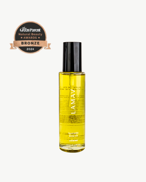 Ayurvedic Body Oil Unwind by LAMAV — yellow bottle next to a bronze beauty award | Relaxes the mind and nourishes skin