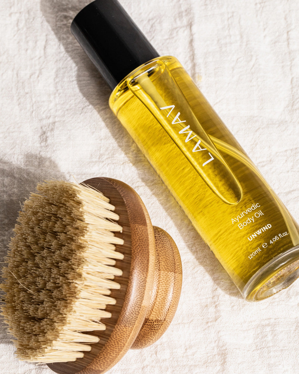Ayurvedic Body Oil Unwind by LAMAV — yellow bottle next to a bronze beauty award | Relaxes the mind and nourishes skin