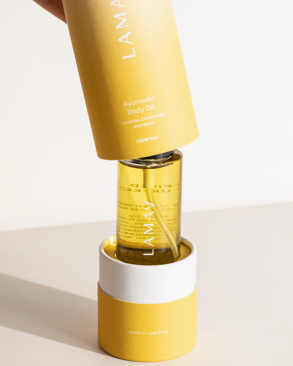 Ayurvedic Body Oil Unwind by LAMAV — yellow bottle next to a bronze beauty award | Relaxes the mind and nourishes skin