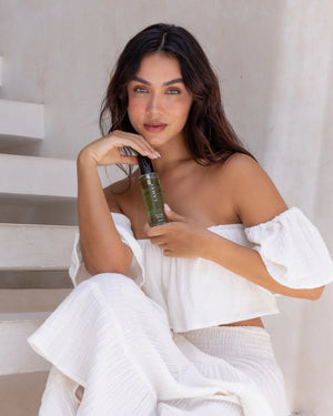 Ayurvedic Body Oil Uplift by LAMAV — woman in white holding the green bottle | Revitalizes skin and senses