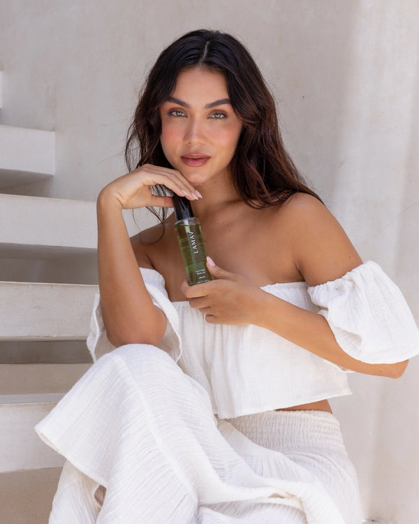 Ayurvedic Body Oil Uplift by LAMAV — woman in white holding the green bottle | Revitalizes skin and senses