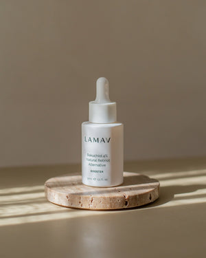 Bakuchiol 4% Booster by LAMAV — bottle resting on a round stone block in sunlight | clean beauty formulation