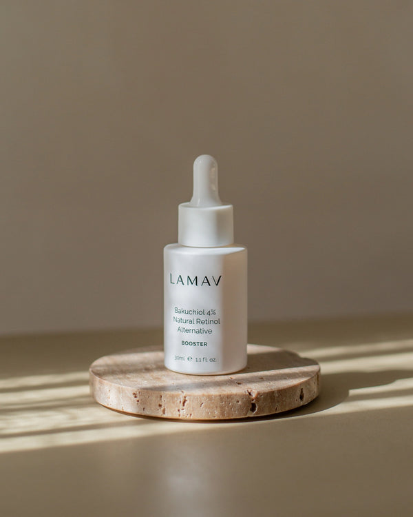 Bakuchiol 4% Booster by LAMAV — bottle resting on a round stone block in sunlight | clean beauty formulation