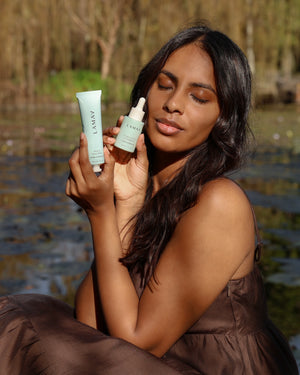 Beauty Sleep Mask by LAMAV — woman by a pond holding the tube and a serum bottle | repairs skin overnight