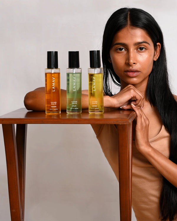 Body Oil Trio by LAMAV — three body oil bottles standing on a wooden table with model | Hydrate and glow