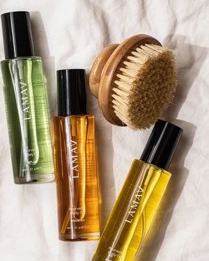 Body Oil Trio by LAMAV — three oil bottles and a wooden body brush on linen | Enhances your body care ritual