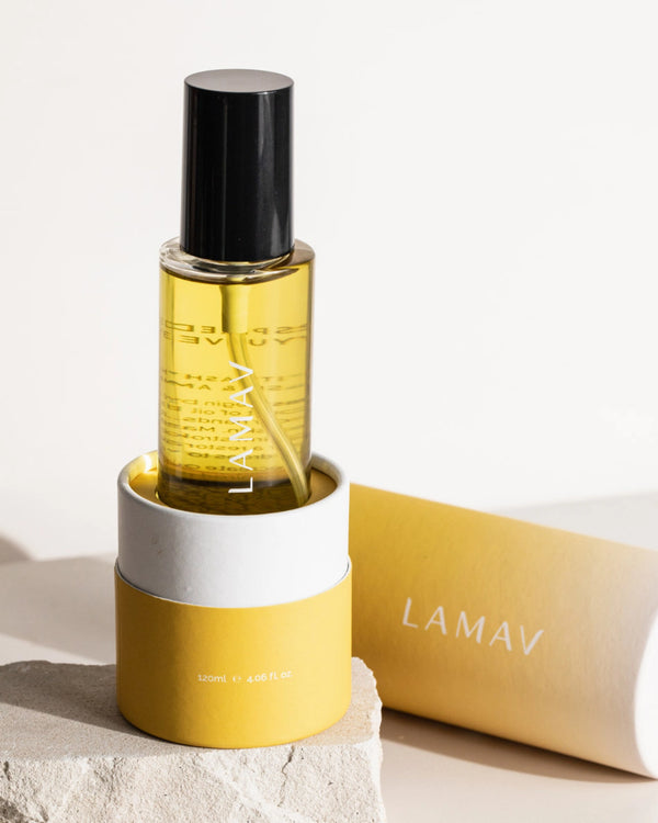 Body Oil Trio by LAMAV — yellow Unwind bottle in its base packaging on a stone | Relax and soothe dry skin