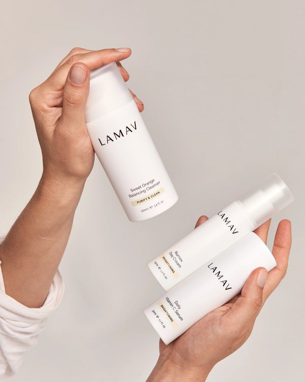 Brightening Essentials Set by LAMAV — two hands holding the cleanser, serum, and day cream | Complete brightening routine