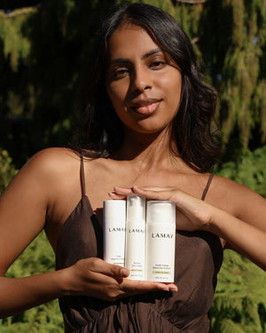 Brightening Essentials Set by LAMAV — smiling woman holding the three bottles outdoors | Achieve a radiant complexion