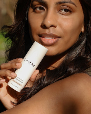 Commiphora Plumping Serum by LAMAV — woman holding bottle near her face outdoors | Plumps and firms facial skin