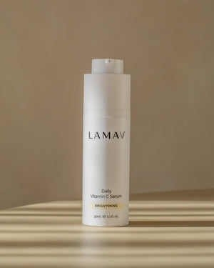 Daily Vitamin C Serum by LAMAV — white bottle standing on a table in striped sunlight | Potent antioxidant protection