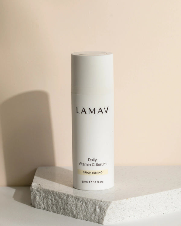 Daily Vitamin C Serum by LAMAV — bottle standing on a textured white stone | Defends against free radicals