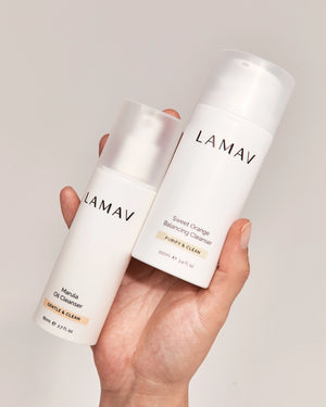 Double Cleansing Duo II by LAMAV — hand holding the oil and gel cleanser bottles | Removes makeup and impurities