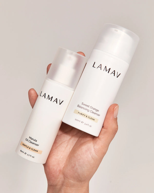 Double Cleansing Duo II by LAMAV — hand holding the oil and gel cleanser bottles | Removes makeup and impurities
