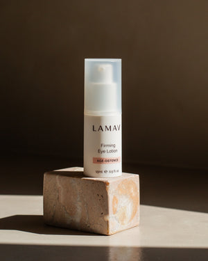 Firming Eye Lotion by LAMAV — bottle standing on a square marble block in sunlight | Rejuvenates tired eyes