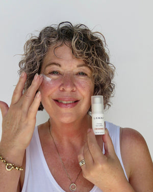 Firming Eye Lotion by LAMAV — smiling woman applying lotion under her eye | smooths fine lines and wrinkles