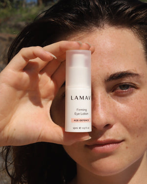Firming Eye Lotion by LAMAV — woman holding the bottle up close to her face outdoors | Restores a youthful appearance