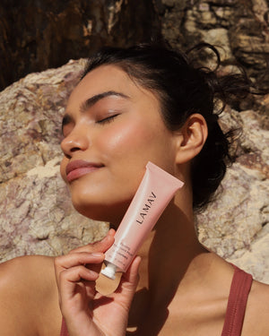 Firming Treatment Mask by LAMAV — young woman holding the pink tube to her neck outdoors | lifts and firms neck and face