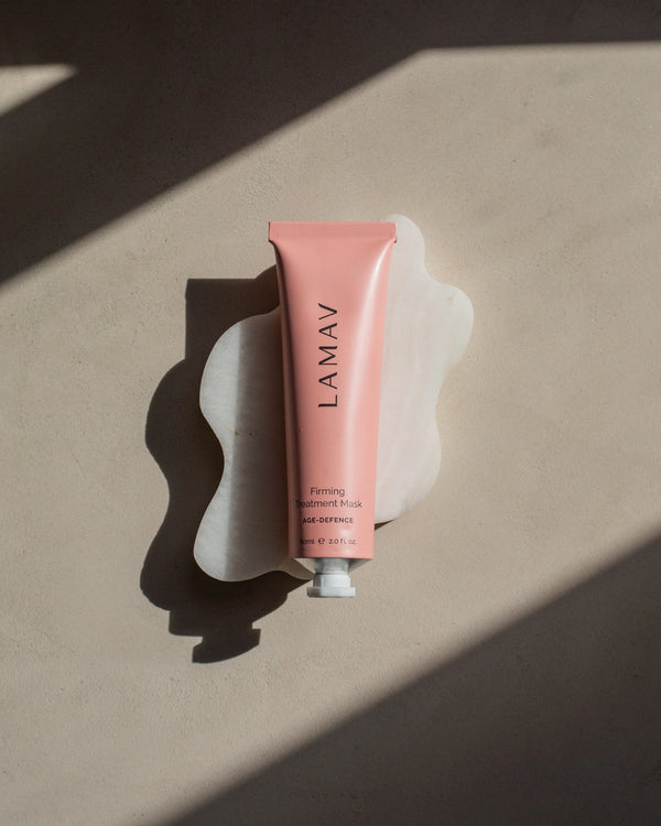 Firming Treatment Mask by LAMAV — pink tube on a white wavy stone with hard shadows | visibly tightens and smooths skin