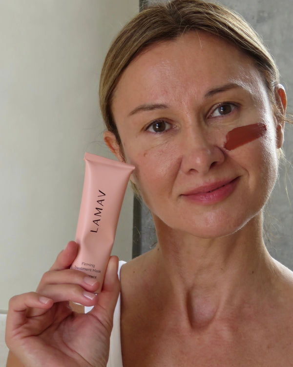 Firming Treatment Mask by LAMAV — woman holding the tube with a swipe of mask on her cheek | Reduces fine lines and wrinkles