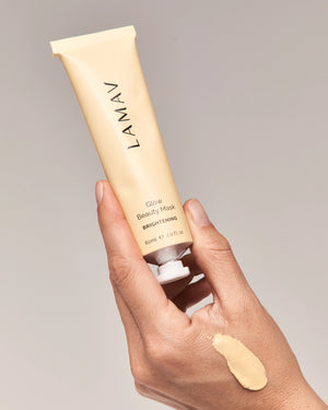 Glow Beauty Mask by LAMAV — hand holding the tube with a creamy yellow swatch | Promotes a healthy radiant glow