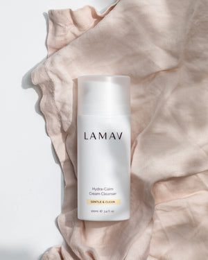 Hydra-Calm Cream Cleanser by LAMAV — 100ml white bottle resting on pink linen | Softens and calms dry skin
