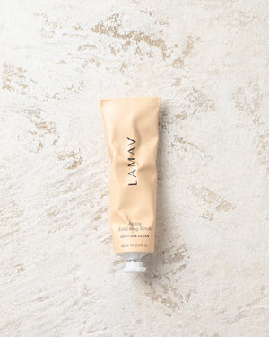 Jojoba Exfoliating Scrub by LAMAV — tube resting flat on textured stone | gentle organic scrub