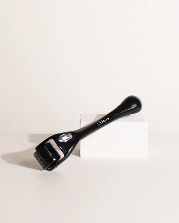Micro Dermal Roller by LAMAV — resting diagonally on a white rectangular block | improves skin texture