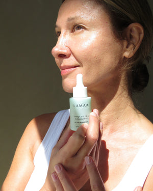Omega 3, 6, 7 & 9 Antioxidant Oil by LAMAV — smiling woman holding bottle | glowing skin