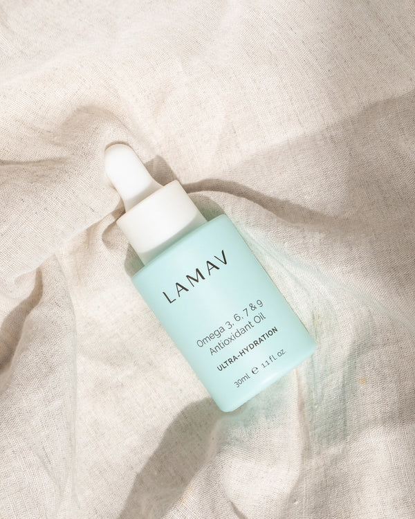 Omega 3, 6, 7 & 9 Antioxidant Oil by LAMAV — bottle resting on linen fabric | antioxidant care