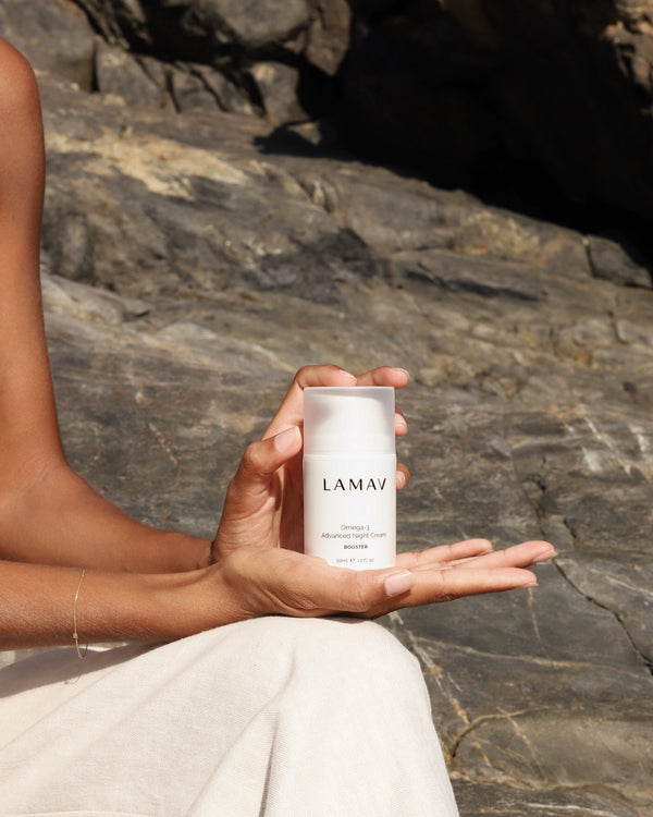 Omega-3 Advanced Night Cream by LAMAV — woman holding bottle against rocks | overnight repair