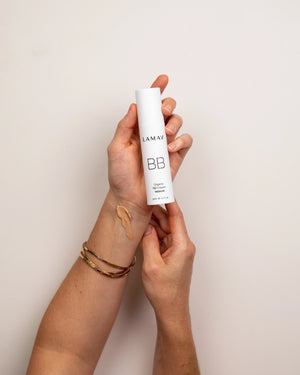Organic BB Cream by LAMAV — hand holding bottle with Medium shade swatch | glowing Australian beauty