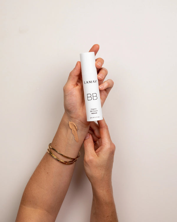 Organic BB Cream by LAMAV — hand holding bottle with Medium shade swatch | glowing Australian beauty