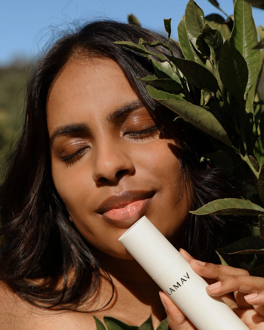 Organic Bio-Active Primer by LAMAV — woman holding bottle amidst green leaves | radiant natural complexion