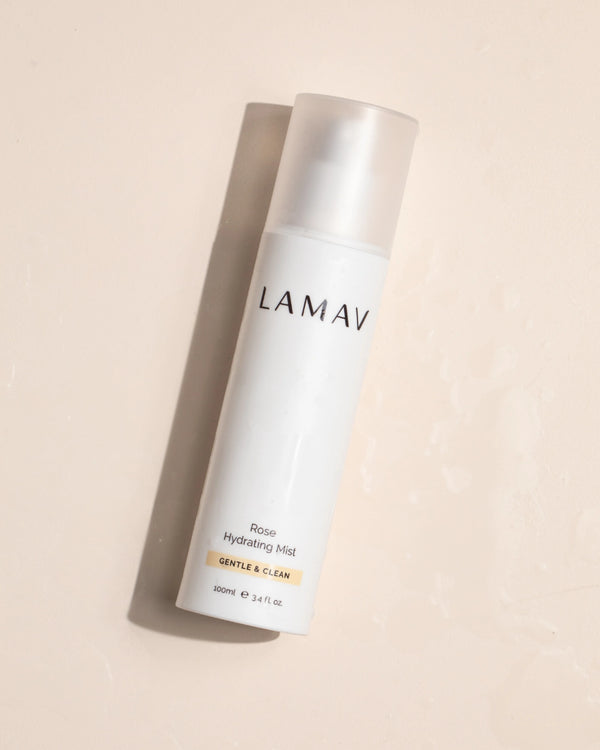Rose Hydrating Mist by LAMAV — bottle lying flat on a wet surface | dewy moisture boost