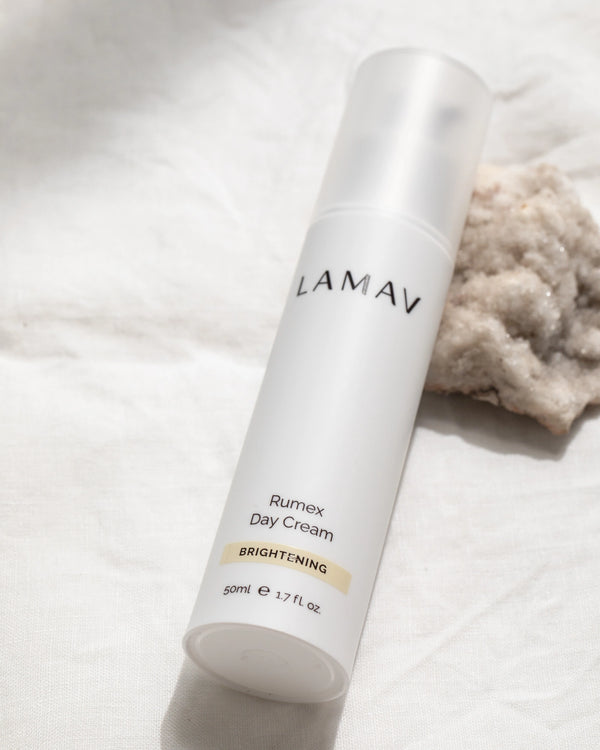 Rumex Advanced Lightening Cream by LAMAV — bottle next to raw crystal on linen | targets pigmentation