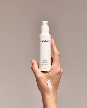 Rumex Advanced Lightening Cream by LAMAV — hand holding bottle with cream swatch | evens skin tone