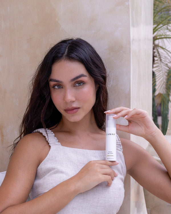 Rumex Advanced Lightening Cream by LAMAV — woman holding white pump bottle | organic brightening care