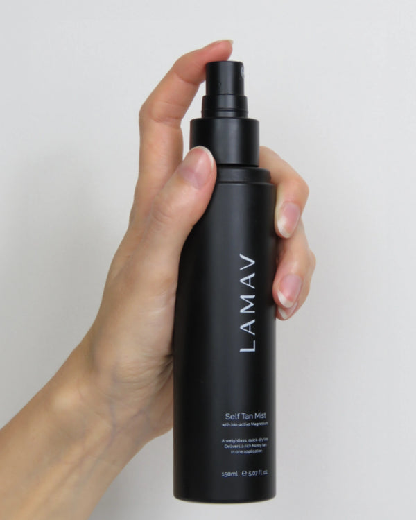 Self Tan Mist by LAMAV — hand holding the black mist bottle | glowing organic tan